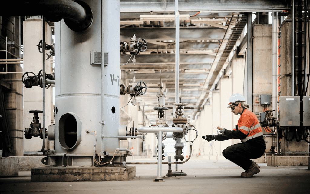 Woman wearing hi-vis working at machinery in a factory