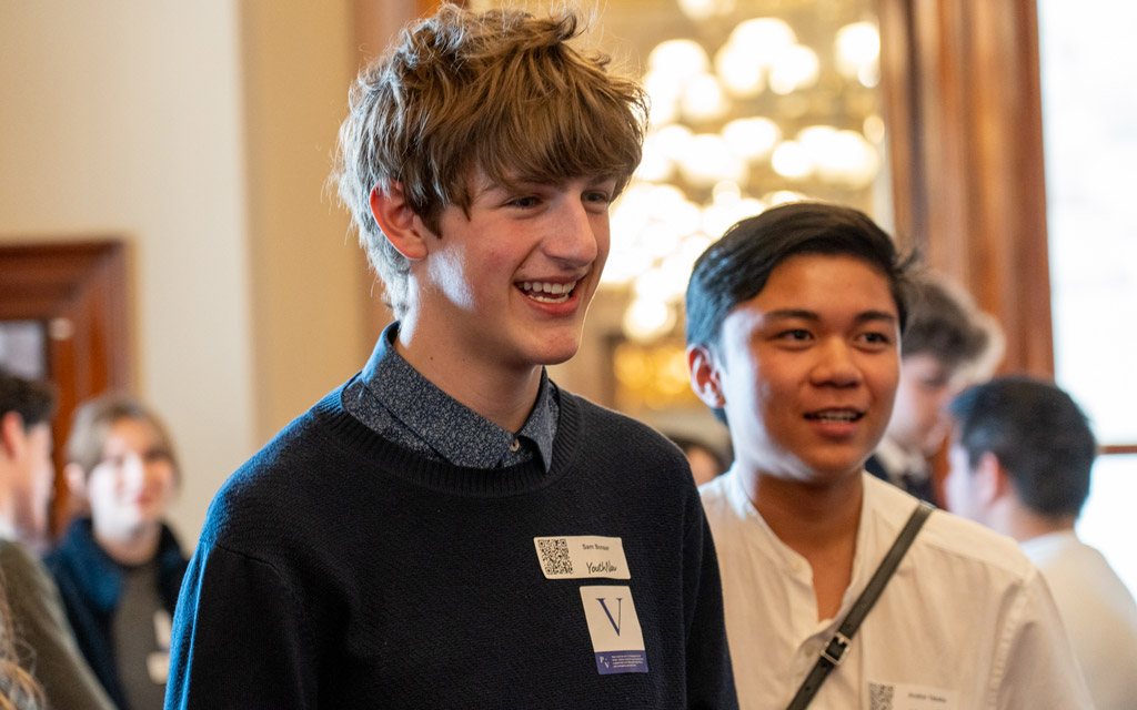 Two young men standing together and smiling.