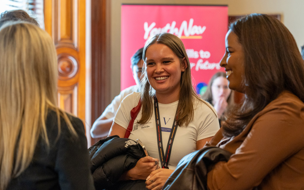 Three women talking and smiling.