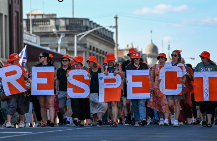 Ballarat community marching through their main street holding a sign saying 'Respect'.